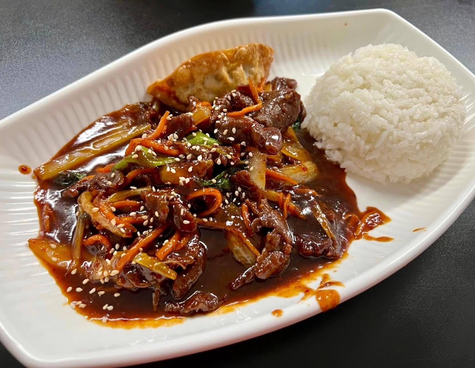 Korean beef with vegetables, steamed rice, and a dumpling